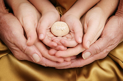 Family Hands together holding a small rock